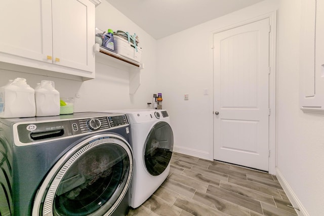 washroom with washer and clothes dryer and cabinets