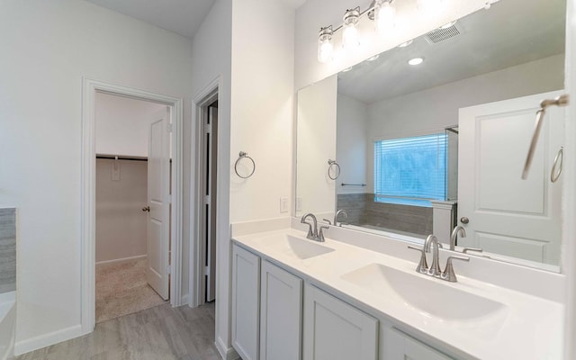 bathroom with a bathtub, wood-type flooring, and vanity