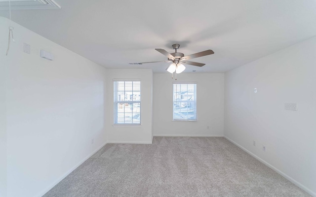 spare room with ceiling fan and light carpet