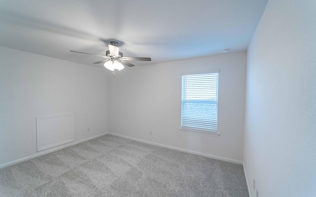 carpeted spare room with ceiling fan