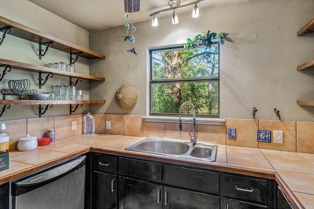 kitchen featuring tile counters, decorative backsplash, dishwashing machine, and sink