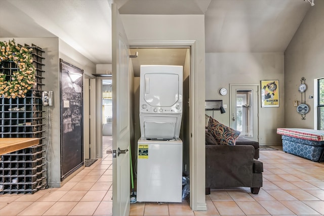 interior space featuring stacked washing maching and dryer, a wealth of natural light, and light tile patterned flooring