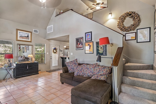 tiled living room featuring ceiling fan and high vaulted ceiling