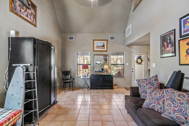 living room with light tile patterned flooring and high vaulted ceiling