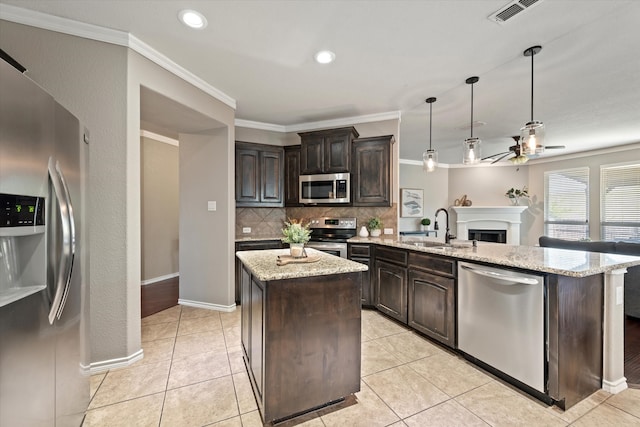 kitchen featuring dark brown cabinets, pendant lighting, appliances with stainless steel finishes, and a kitchen island