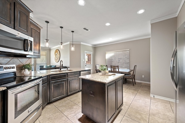 kitchen featuring appliances with stainless steel finishes, dark brown cabinets, a center island, and sink