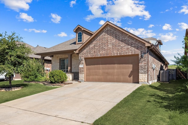 view of front of property with a garage, central AC unit, and a front lawn