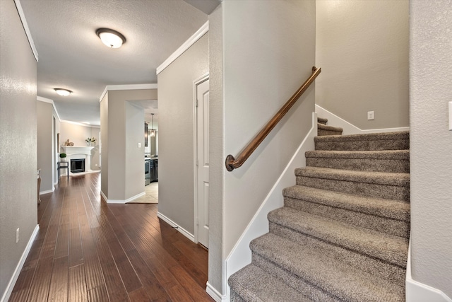 interior space featuring ornamental molding, a textured ceiling, and hardwood / wood-style flooring