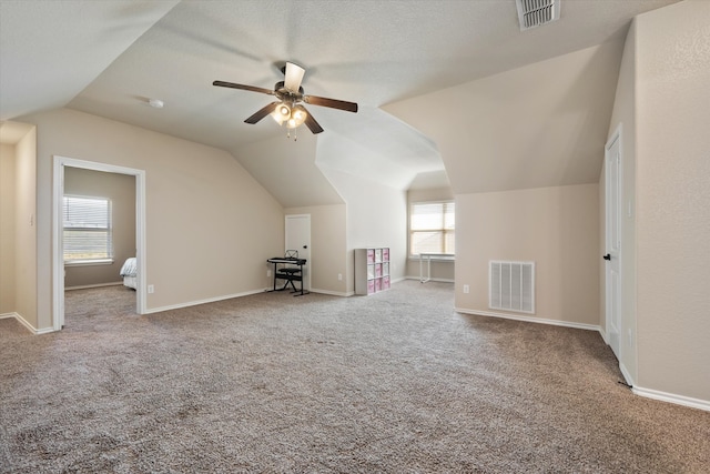 bonus room featuring ceiling fan, carpet floors, vaulted ceiling, and a textured ceiling