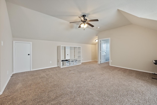 additional living space featuring carpet floors, vaulted ceiling, and ceiling fan