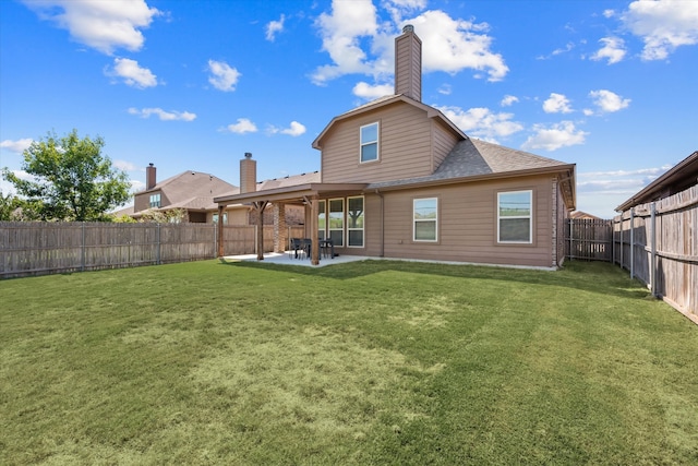 rear view of house with a lawn and a patio