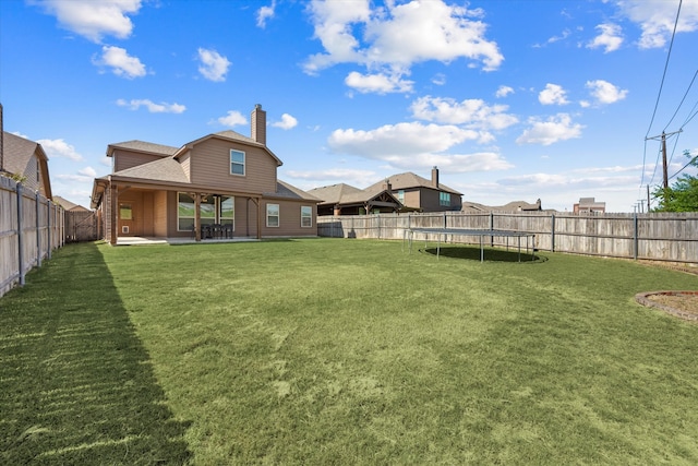 view of yard with a trampoline and a patio area