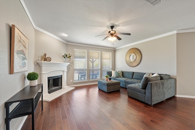 living room with a textured ceiling, ornamental molding, ceiling fan, and dark wood-type flooring