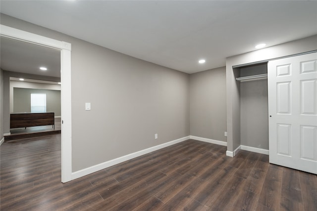 unfurnished bedroom with a closet and dark hardwood / wood-style flooring