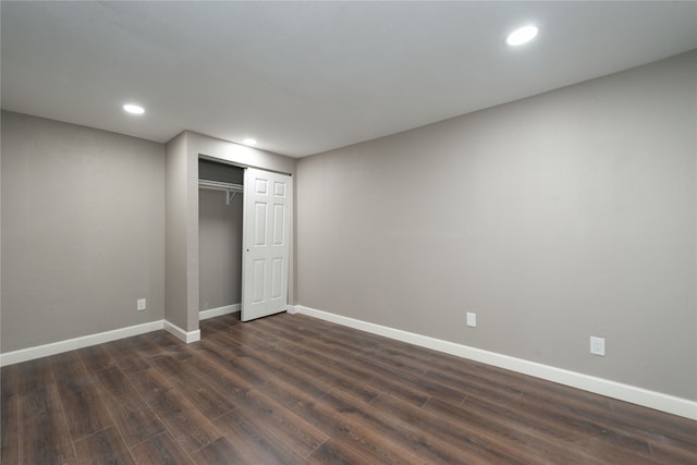 unfurnished bedroom featuring a closet and dark wood-type flooring