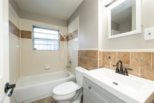 full bathroom with vanity, tile walls, tiled shower / bath combo, and toilet