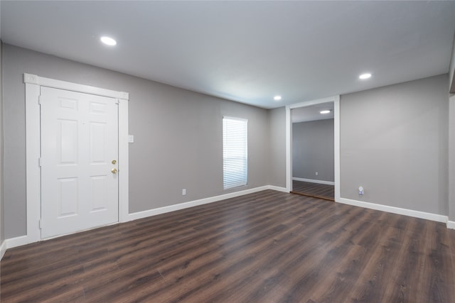 unfurnished room with dark wood-type flooring