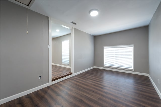 spare room with dark hardwood / wood-style floors and a healthy amount of sunlight