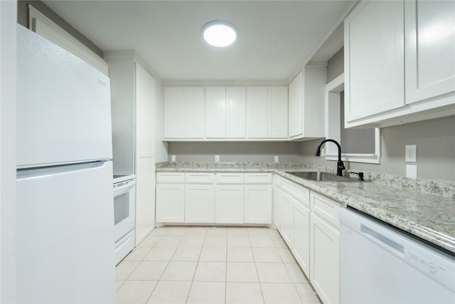 kitchen featuring light stone counters, white cabinets, sink, and white appliances