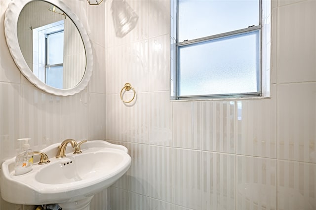 bathroom featuring sink and tile walls