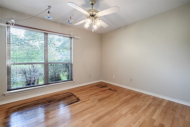 spare room featuring light wood-type flooring, a healthy amount of sunlight, and ceiling fan