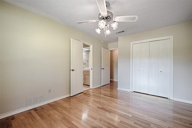 unfurnished bedroom featuring a closet, ceiling fan, a textured ceiling, and light hardwood / wood-style floors