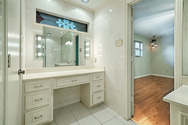 bathroom with vanity, hardwood / wood-style floors, tile walls, and ornamental molding