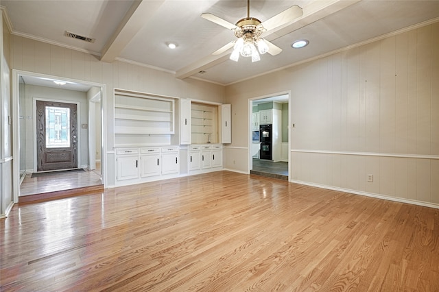 unfurnished living room featuring crown molding, light wood-type flooring, and built in shelves