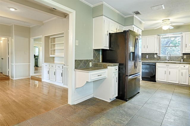 kitchen featuring light hardwood / wood-style flooring, white cabinetry, black dishwasher, and backsplash