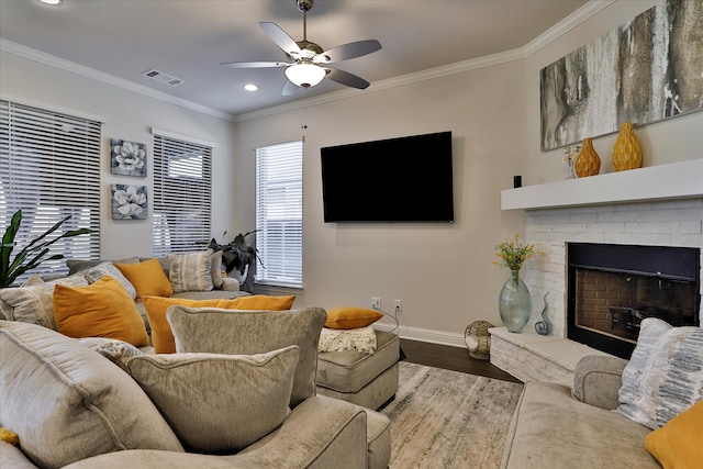 living room featuring crown molding, a fireplace, hardwood / wood-style floors, and ceiling fan