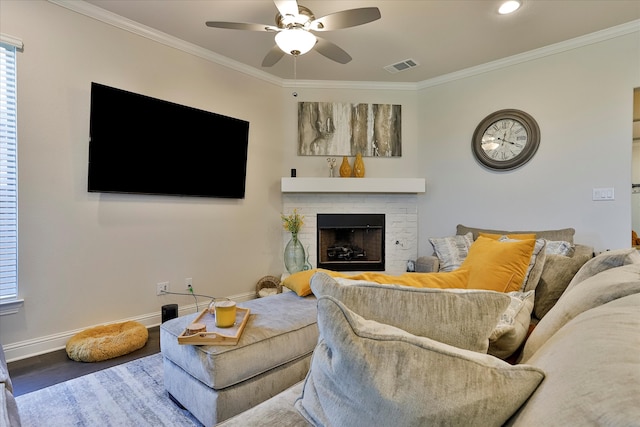 living room with crown molding, hardwood / wood-style floors, ceiling fan, and a brick fireplace