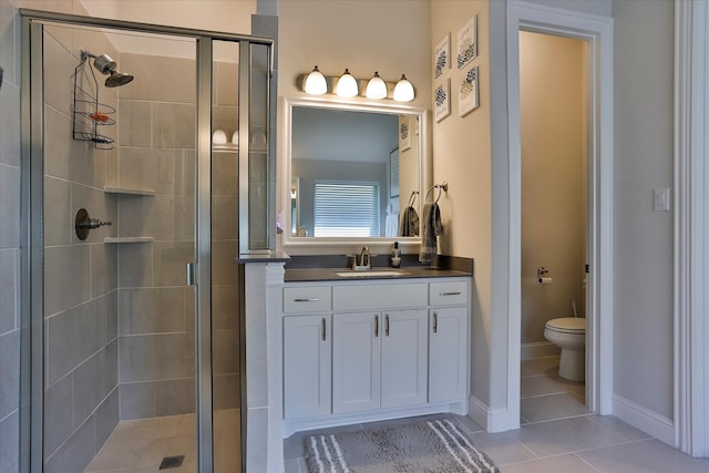 bathroom with vanity, toilet, a shower with door, and tile patterned floors