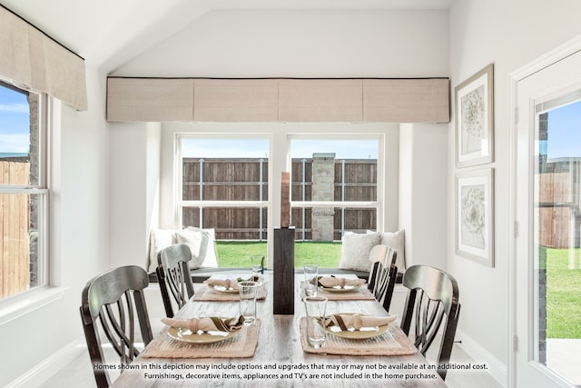 dining space with a wealth of natural light and vaulted ceiling