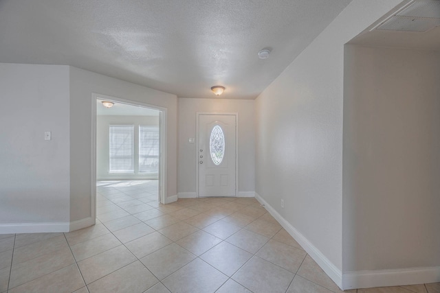 tiled foyer entrance with a textured ceiling