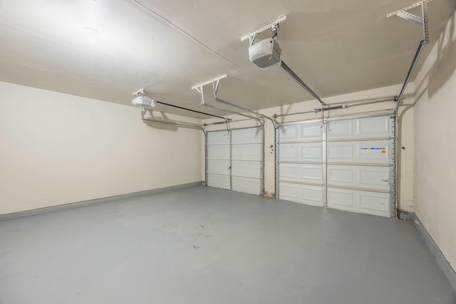 garage featuring a garage door opener and baseboards