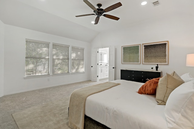 carpeted bedroom featuring ceiling fan, lofted ceiling, and ensuite bath