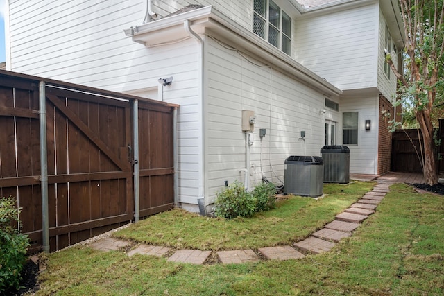 view of home's exterior featuring central AC unit and a lawn