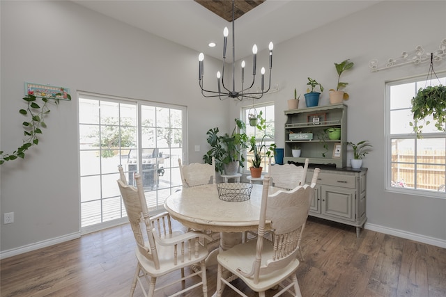 dining area featuring a high ceiling, a chandelier, and dark hardwood / wood-style flooring