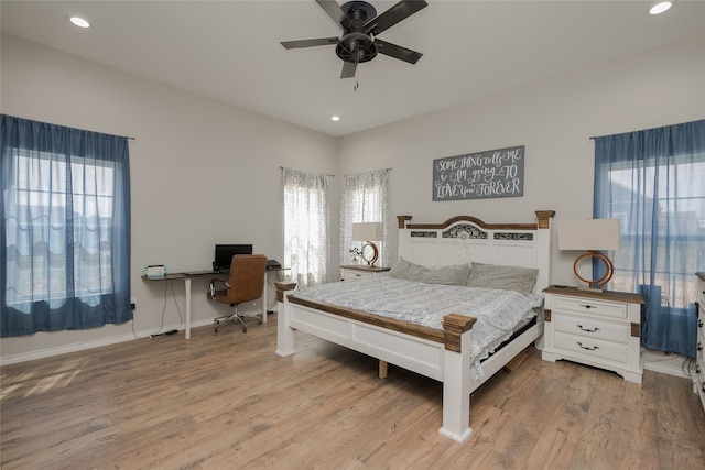 bedroom featuring ceiling fan, light hardwood / wood-style floors, and multiple windows