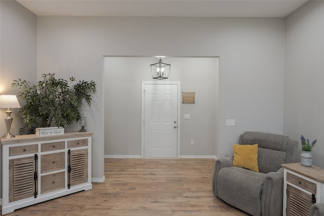 entryway with light hardwood / wood-style floors and an inviting chandelier