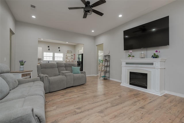 living room with ceiling fan and light wood-type flooring