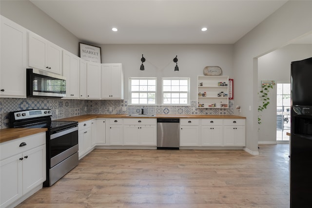 kitchen featuring appliances with stainless steel finishes, a wealth of natural light, light wood-type flooring, and white cabinets