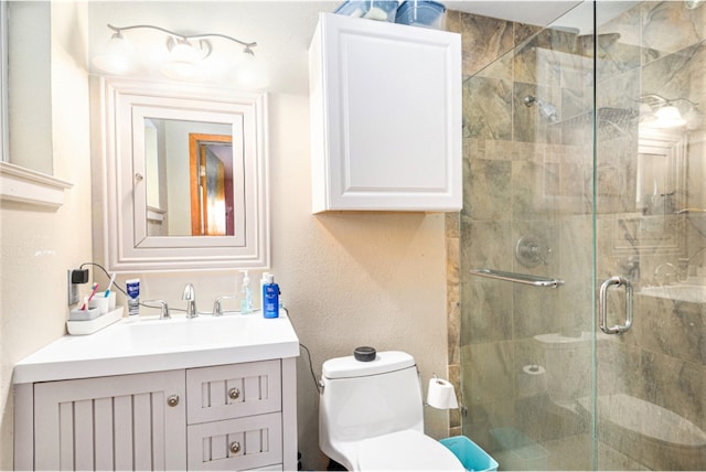 bathroom featuring toilet, vanity, and an enclosed shower