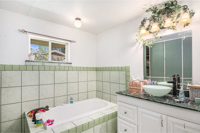 bathroom with vanity and tiled tub