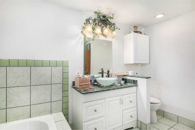 bathroom with vanity, toilet, tile patterned floors, and a bathtub