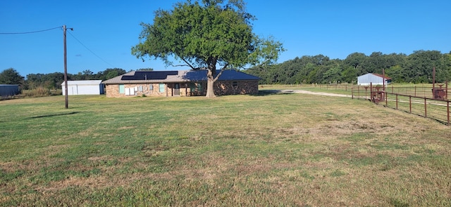 view of yard with an outdoor structure and a rural view