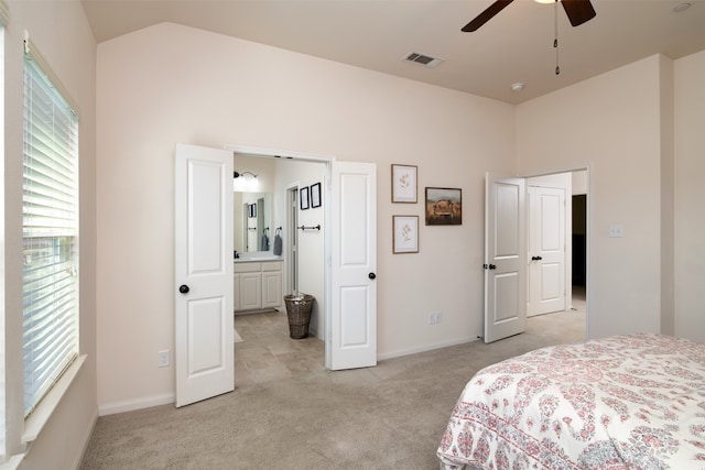 carpeted bedroom with vaulted ceiling, ceiling fan, and ensuite bathroom