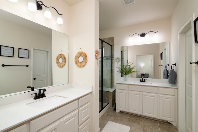 bathroom featuring tile patterned flooring, a shower with shower door, and vanity