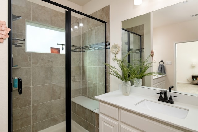 bathroom featuring walk in shower and vanity