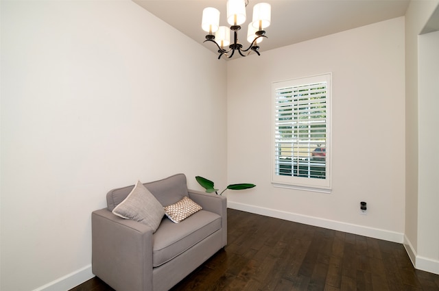 sitting room with an inviting chandelier and dark wood-type flooring